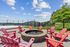 Inviting outdoor space with vibrant red Adirondack chairs around a cozy fire pit, perfect for summer evenings.