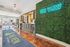 Welcoming lobby entrance at The View Apartments with modern decor, vibrant green wall feature, and sleek check-in counter.