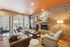 Warm and inviting living space with exposed brick walls, cozy seating, and a modern fireplace, perfect for relaxation and comfort.