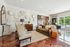Elegant living room with modern decor, cozy seating, and large windows offering a poolside view.