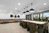 Contemporary dining area with plush seating, stylish pendant lighting, and floor-to-ceiling windows showcasing scenic views.