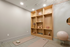 Elegant home yoga room with soft lighting, featuring two yoga mats, stylish shelving with decorative items, and a yoga ball for a serene workout environment.