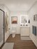Modern bathroom featuring sleek design with a spacious vanity, illuminated mirror, and stylish artwork, complemented by wooden flooring for a warm ambiance.