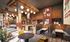 Contemporary and inviting communal space with cozy booths, stylish wooden decor, and vibrant lighting, perfect for socializing or relaxing.