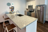 Modern apartment kitchen with granite countertops, sleek stainless steel appliances, and contemporary seating.