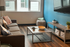 Inviting living room featuring a cozy sofa, modern coffee table, blue accent wall, and abundant natural light.