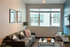 Cozy modern living room with stylish decor, large windows, and a comfortable sofa.