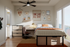 Inviting bedroom with modern decor, featuring a cozy bed, stylish wall art, and ample natural light from large windows.
