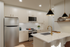 Modern kitchen design with elegant pendant lighting, sleek stainless steel appliances, and chic marble countertops.