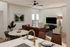 Modern living space with elegant open-concept design featuring cozy seating area, stylish dining set, and sleek kitchen island overlooking a serene landscape.