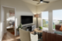 Cozy living room with stylish decor, featuring a plush sofa, modern TV setup, and access to a balcony with stunning views.