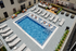 Luxurious outdoor pool area featuring stylish lounge chairs, cozy fire pit, and modern seating, perfect for relaxation and entertainment.