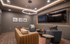 Sophisticated lounge room featuring modern lighting, plush seating, and a large wall-mounted television for a luxurious entertainment experience.