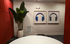Modern room with stylish red acoustic panels, lush indoor plant, contemporary headphone artwork, and sleek round table.