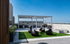 Stunning rooftop lounge with modern seating, barbecue grill, and panoramic city views under a clear blue sky.