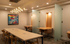 Elegant and modern shared work space featuring a sleek wooden table, stylish chairs, ambient lighting, and inspiring artwork.