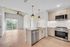Modern living space with elegant open-concept design featuring cozy seating area, stylish dining set, and sleek kitchen island overlooking a serene landscape.