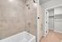 Elegant bathroom interior featuring a modern vanity with a gold-framed mirror, polished fixtures, and a cozy shower area with soft lighting.
