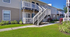 Charming apartment exterior with modern balconies, lush landscaping, and inviting walkways.
