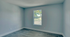 Bright, empty room with large window, sleek flooring, and clean, modern design, ready for customization.