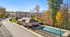 Inviting apartment complex surrounded by vibrant fall foliage, featuring thoughtfully maintained grounds and ample parking.