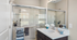 Elegant bathroom with glass shower doors, sleek vanity, and tasteful decor, offering a serene ambiance.