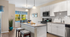 Bright and modern kitchen with sleek countertops, stainless steel appliances, and elegant pendant lighting. Cozy dining area with a view and stylish decor.