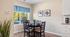 Charming dining area with elegant round table, inviting natural light, and modern wall art.