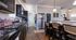 Warm and inviting kitchen featuring dark wood cabinets, a bar countertop with seating, and elegant pendant lighting.