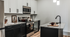 Stylish open-concept living room with modern furniture and a sleek kitchen design.
