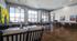Elegant and modern office space with high ceilings, large windows, and stylish decor featuring lush green plant wall and contemporary furniture.