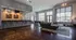 Modern lounge area with large windows, comfortable seating, a sleek bar, and a pool table, perfect for both relaxing and entertaining.