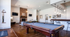 Chic modern lounge with a cozy fireplace, elegant pool table, and contemporary bar seating, perfect for relaxing and entertaining.