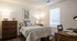 Cozy bedroom with warm lighting, stylish decor, and comfortable bedding in a modern apartment.