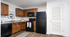 Charming kitchen with rich wooden cabinets, sleek granite countertops, and modern black appliances for a polished look.