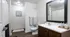 Modern bathroom with elegant dark wood cabinetry, large mirror, and sleek fixtures, creating a luxurious and inviting atmosphere.