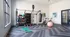Bright and modern fitness room featuring a well-equipped workout station with weights, kettlebells, a punching bag, exercise bikes, and a large yoga ball, perfect for versatile workouts.