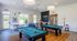 Modern recreational room with two pool tables and vibrant seating, perfect for entertainment and social gatherings.