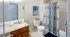 Chic bathroom with elegant granite countertop, modern fixtures, and stylish geometric shower curtain.