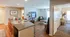 Inviting open-plan living area with a sleek granite kitchen island, cozy seating, and natural light, perfect for modern living.