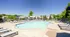 Inviting outdoor swimming pool with sun loungers and lush greenery, perfect for relaxation and enjoyment.
