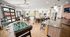 Bright and inviting entertainment area featuring a foosball table, pool table, cozy seating, and modern decor with large windows and ample natural light.