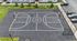 Modern community basketball court surrounded by greenery and convenient parking, perfect for recreation and relaxation.