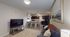 Chic modern living space featuring an inviting open-concept layout with a cozy seating area, elegant bar stools at the kitchen counter, and stylish decor.