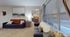 Inviting living room with modern decor, featuring comfy sofas, a large landscape painting, and a well-lit adjoining bedroom.