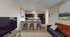 Inviting open-concept kitchen and living area featuring a sleek countertop with bar seating, modern pendant lighting, and stylish decor.