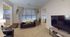 Inviting living room with stylish leather seating, large windows with elegant curtains, and modern d&eacute;cor in a cozy apartment setting.