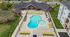 Inviting apartment amenities featuring a uniquely shaped pool surrounded by vibrant yellow loungers and lush green surroundings, perfect for relaxation and outdoor enjoyment.