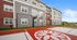 Modern apartment building with vibrant siding overlooking a sleek outdoor basketball court, perfect for sports enthusiasts.