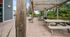 Charming outdoor patio with wooden pergola, picnic tables, and heaters, surrounded by lush greenery for a perfect gathering space.